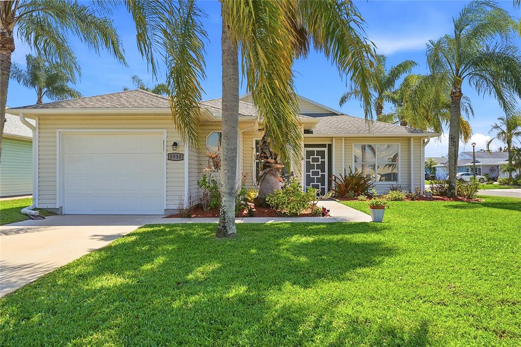 A single-story house with light yellow siding, a white garage door, and palm trees — 5930 FOXTAIL WAY, FORT PIERCE, FL