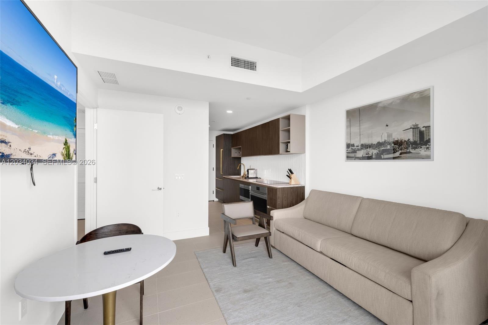 A studio apartment features a kitchenette, a sofa, a dining table, and a wall-mounted television — 601 NE 1st Ave # 4814, Miami FL 33132, MIAMI, FL