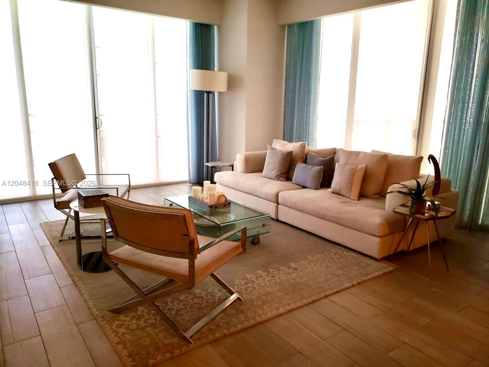 A living room features a beige sofa, two armchairs, a glass coffee table, and floor-to-ceiling windows — 9705 Collins Ave # 2504N, Bal Harbour FL 33154, BAL HARBOUR, FL