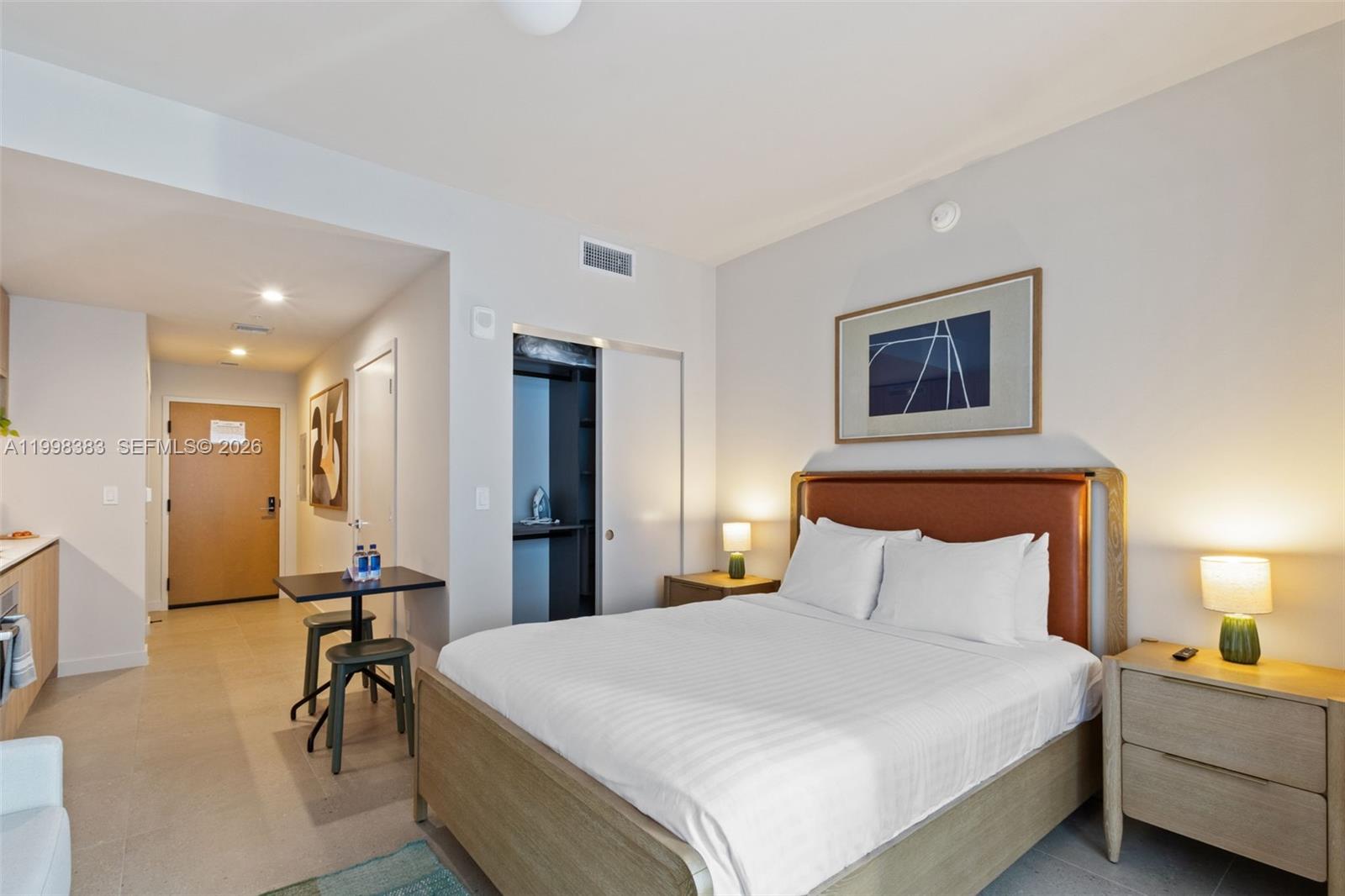 A bedroom features a queen bed, two nightstands with lamps, and a small dining table — 11 NE 6 # 2108, Miami FL 33132, MIAMI, FL