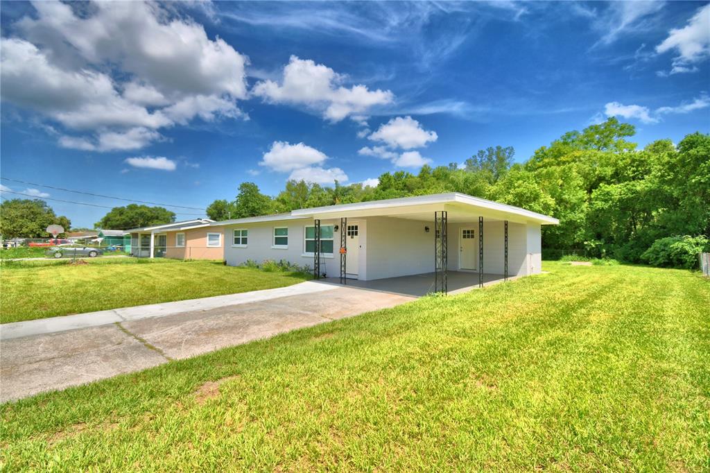 A single-story house with a carport and a concrete driveway sits on a grassy lot — 109 2ND JPV STREET, WINTER HAVEN, FL