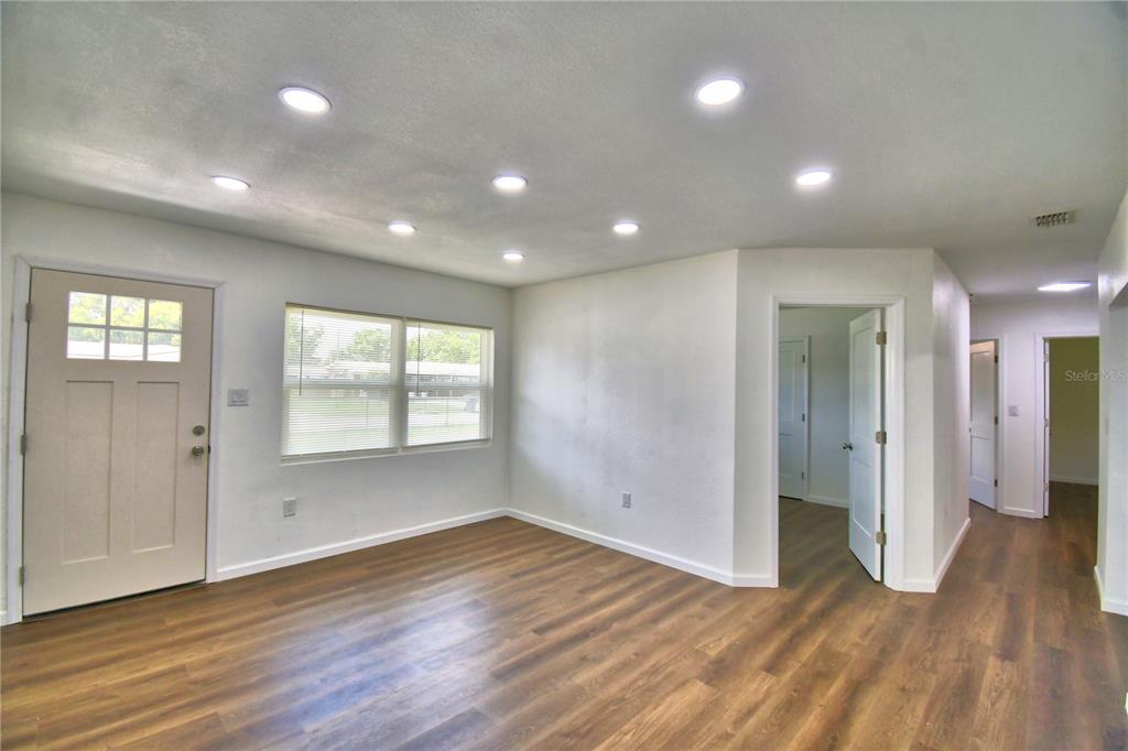 A living room features recessed lighting, white walls, and wood-look flooring — 109 2ND JPV STREET, WINTER HAVEN, FL