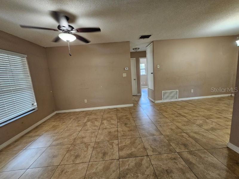 A room with beige walls, a ceiling fan, and light-colored tile flooring — 377 BRITTANY CIRCLE, CASSELBERRY, FL