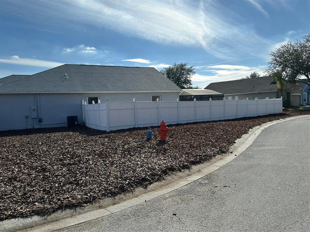 A white vinyl fence encloses the backyard of a house with a gray roof — 1354 KNOLLWOOD DRIVE, DAVENPORT, FL
