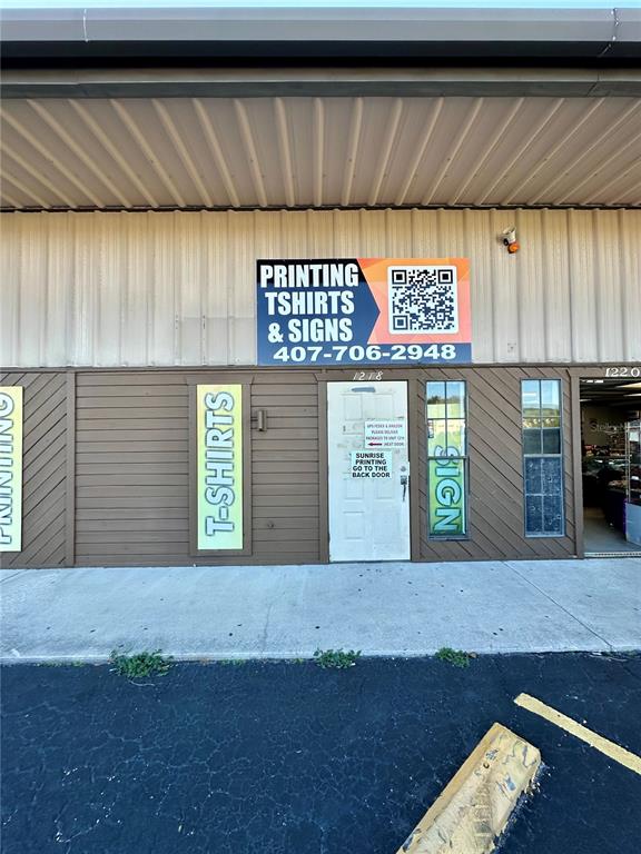 The exterior of a commercial building features a sign for printing, t-shirts, and signs — 1210-1232 DYER BOULEVARD UNIT 1218, KISSIMMEE, FL