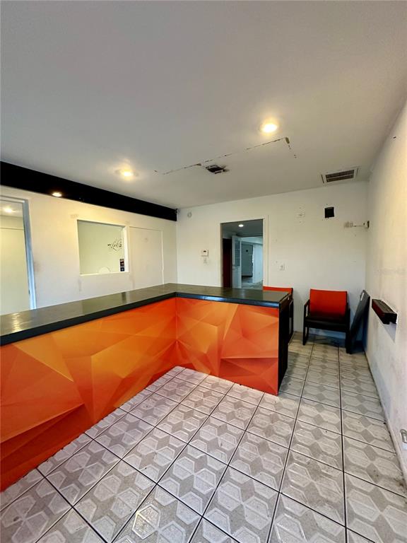 An interior view shows a reception area with a geometric orange desk and tiled flooring — 1210-1232 DYER BOULEVARD UNIT 1218, KISSIMMEE, FL