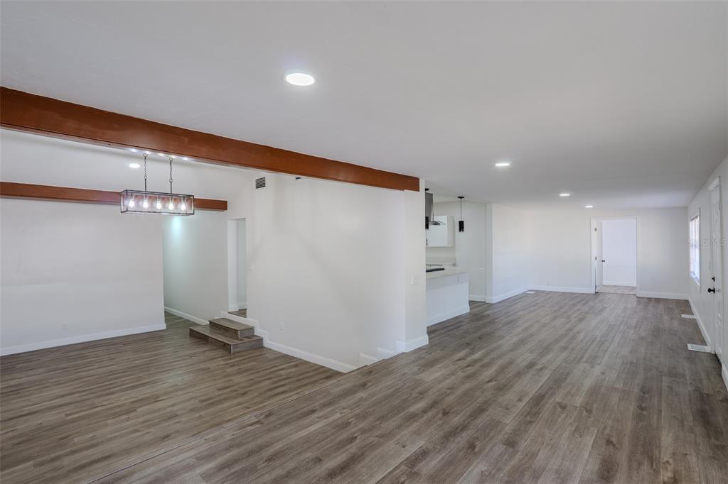 An open-concept living area features wood-look flooring, recessed lighting, and exposed wooden ceiling beams — 599 CAROLINA AVENUE, FORT MYERS, FL