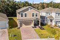 An aerial view shows the front exterior of a two-story suburban house with a driveway — 5277 ROYAL POINT AVENUE, KISSIMMEE, FL