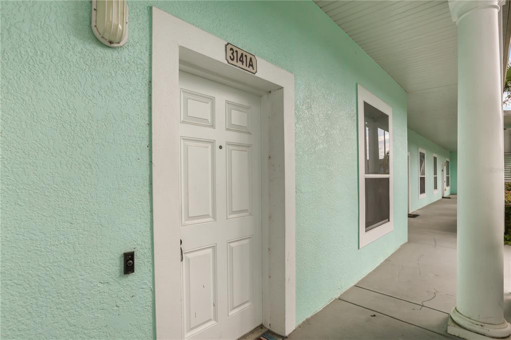 A white front door with the number 3141A above it on a light green exterior wall — 3141 SUN LAKE COURT UNIT A, KISSIMMEE, FL