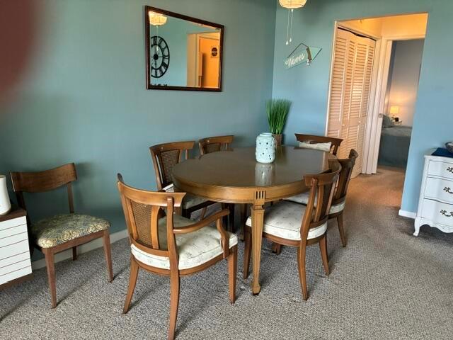 A dining room features a wooden table, six chairs, a wall mirror, and blue walls — 620 Horizon W # 202, Boynton Beach FL 33435, BOYNTON BEACH, FL