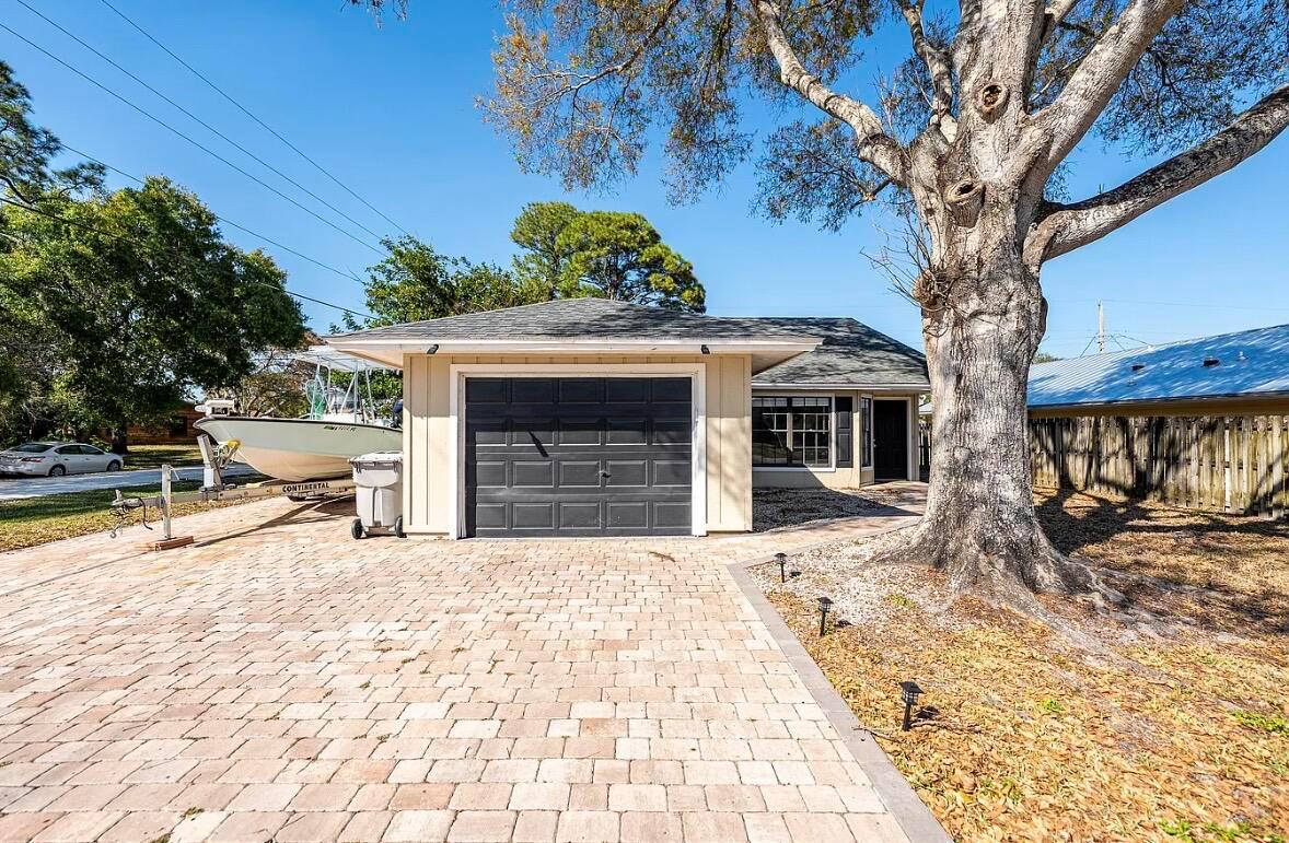 A single-story house with a garage, a paved driveway, and a large tree in front — 2890 1st Place, Vero Beach FL 32968, VERO BEACH, FL