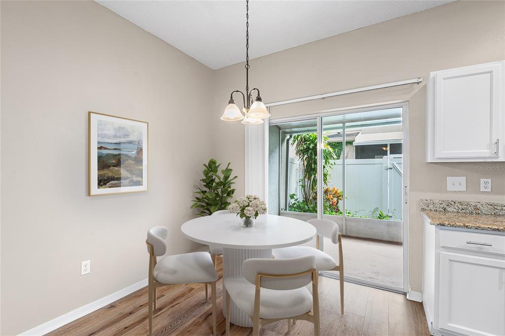 A dining area features a round white table, four chairs, and a sliding glass door — 10114 FARMINGDALE PLACE, TAMPA, FL