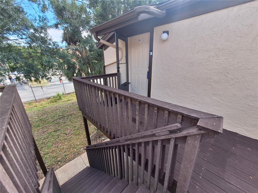 An exterior view shows a wooden staircase leading to a second-story apartment entrance labeled G — 4022 BEAVER LANE UNIT 1000G, PORT CHARLOTTE, FL