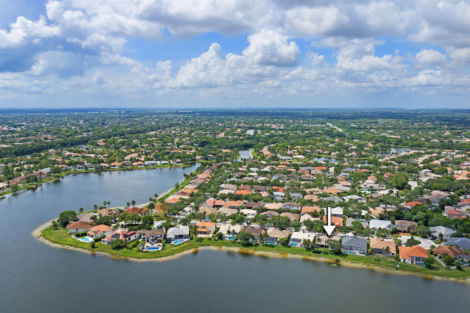 An aerial view shows a residential neighborhood with houses situated along a large lake — 804 Heritage Drive, Weston FL 33326, WESTON, FL