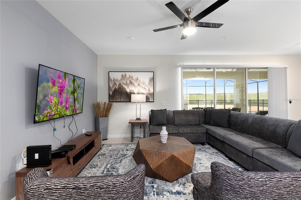 A living room features a sectional sofa, a geometric coffee table, and a wall-mounted television — 2316 LELANI CIRCLE, DAVENPORT, FL