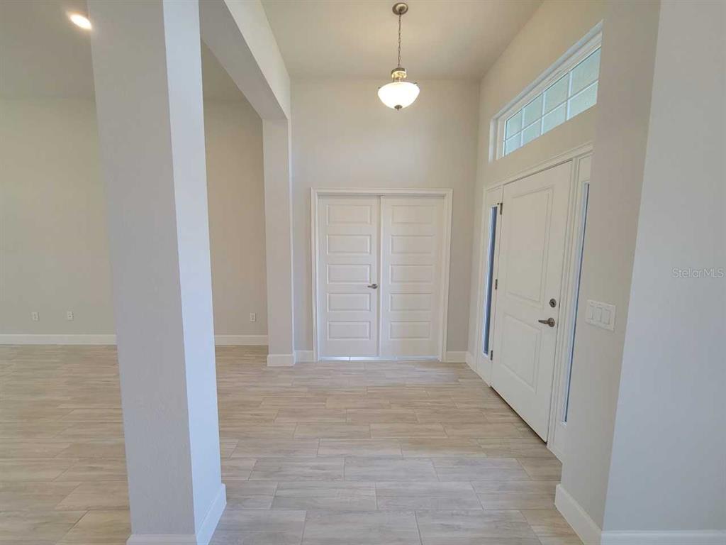 An entryway features light wood-look tile flooring, white walls, and a double-door entrance — 13154 SW 70TH LANE, OCALA, FL
