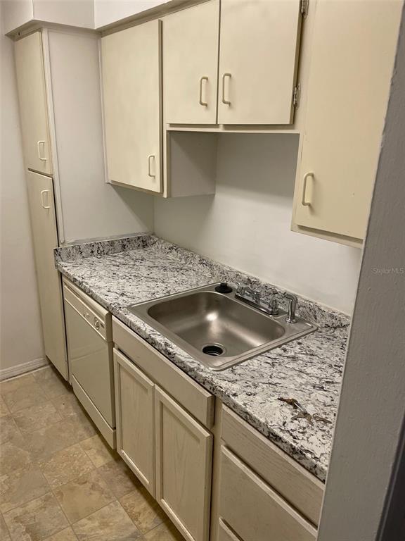 A kitchen features light-colored cabinets, a granite countertop, a stainless steel sink, and a dishwasher — 415 WYMORE ROAD UNIT 101, ALTAMONTE SPRINGS, FL