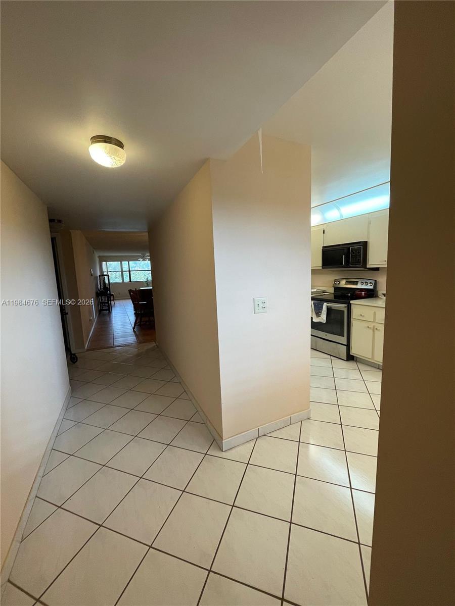 A tiled hallway leads to a kitchen on the right and a dining area ahead — 2606 NW 104th Ave # 301, Sunrise FL 33322, SUNRISE, FL