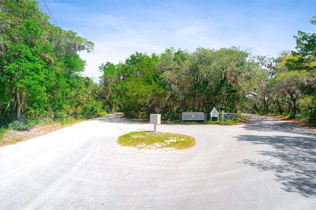 A paved road forks in front of a wooded area with a small circular island — 10474 SALT MARSH TRAIL, JACKSONVILLE, FL