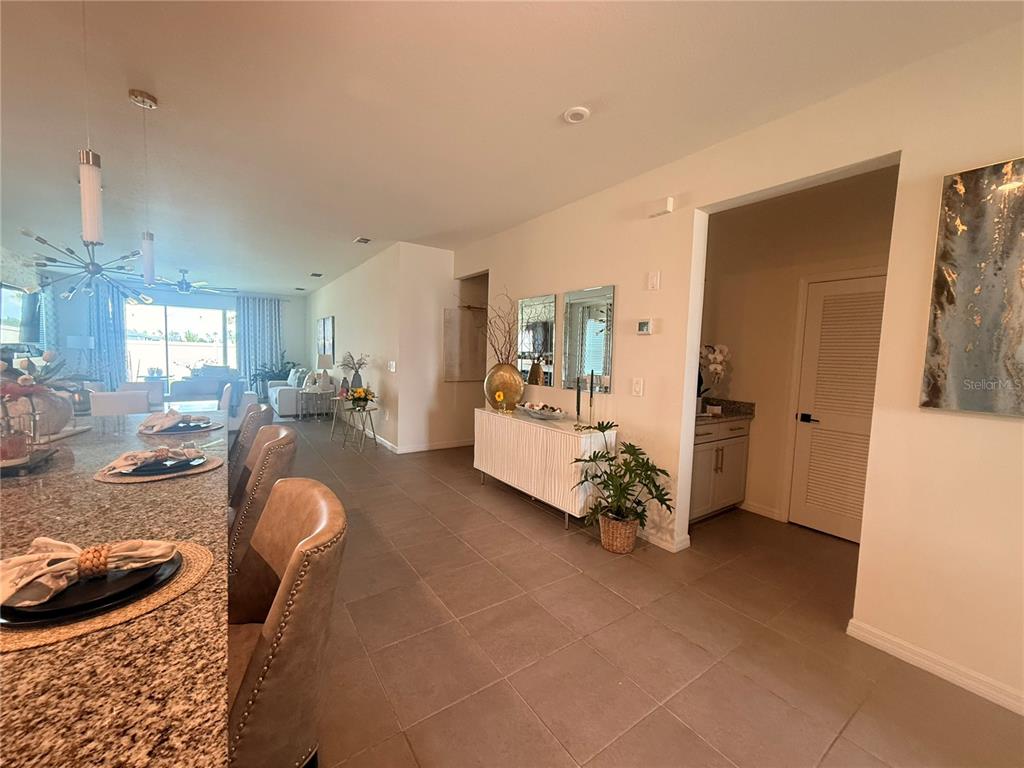A kitchen island with granite countertops overlooks a dining area and a living room — 988 VINEYARD RIDGE ROAD, MINNEOLA, FL
