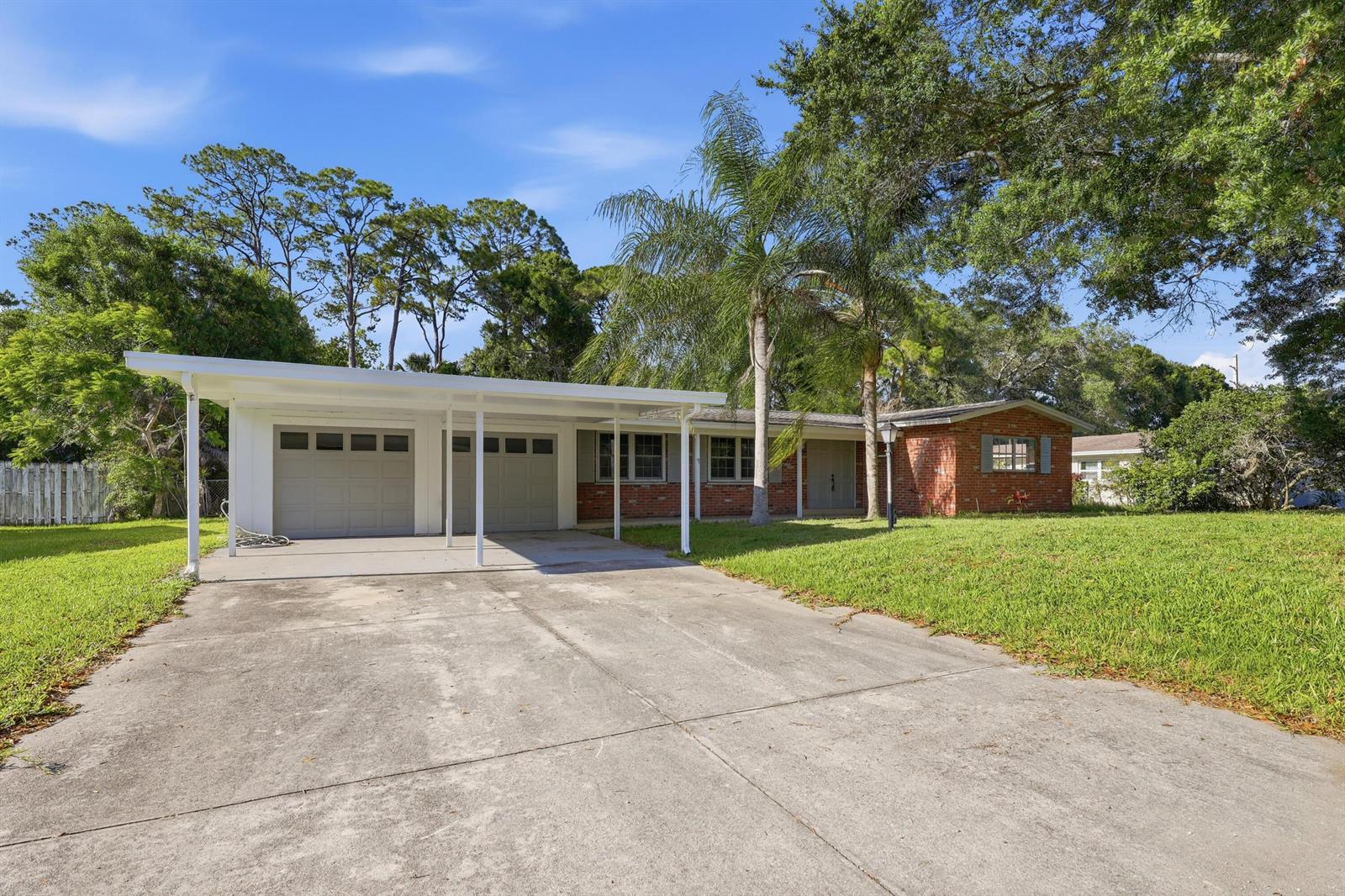 A single-story brick house features a large white carport and a concrete driveway — 2726 6th Place, Vero Beach FL 32968, VERO BEACH, FL