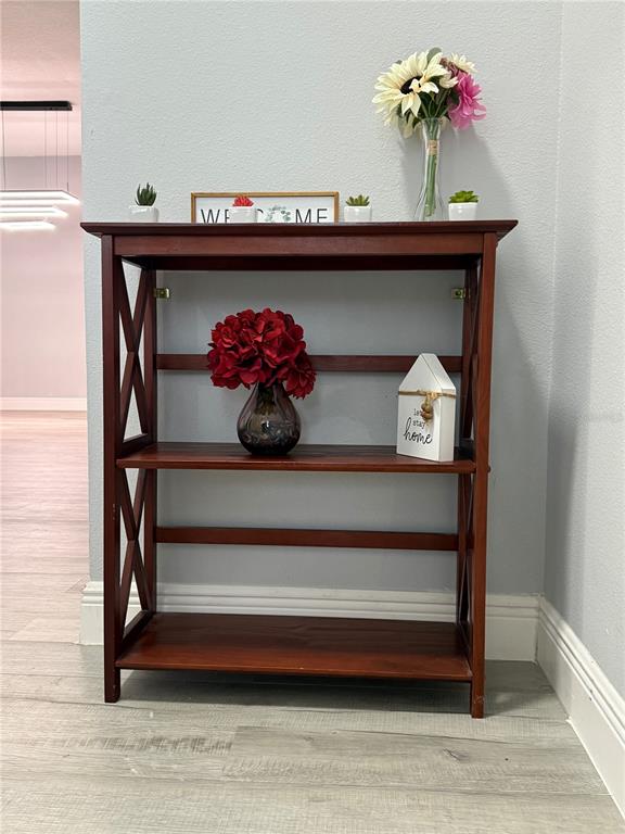 A wooden bookshelf with three shelves stands against a light gray wall — 16321 SAINT AUGUSTINE STREET, CLERMONT, FL
