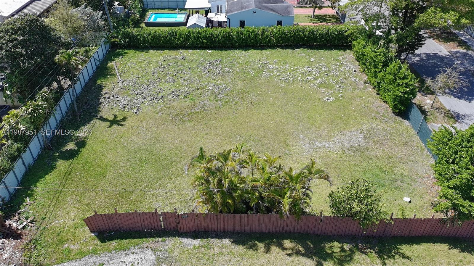 An aerial view of a vacant, grassy residential lot enclosed by fences and trees — 5410 SW 5th Terr, Miami FL 33134, MIAMI, FL