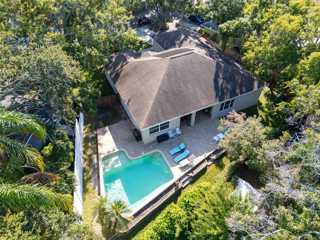 An aerial view shows a house with a shingled roof, patio, and swimming pool — 2270 BARBARA DRIVE, CLEARWATER, FL