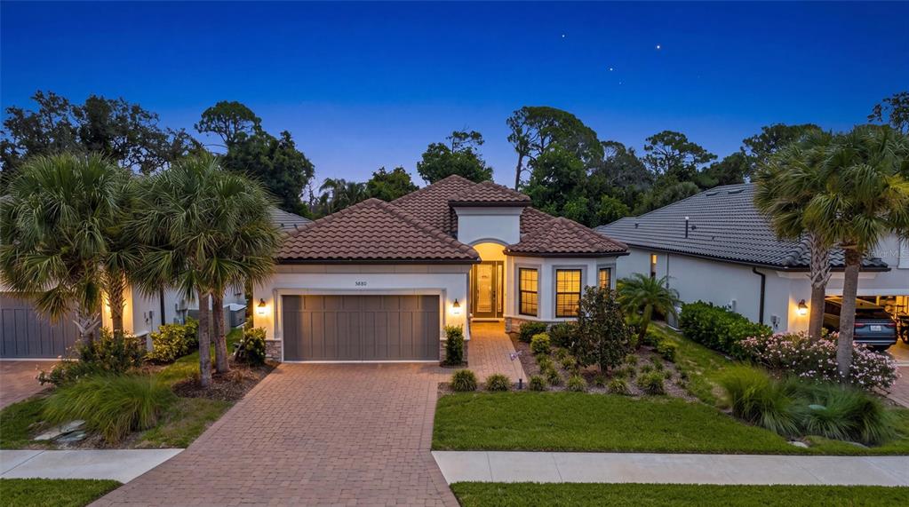 A single-story house with a tiled roof, a brick driveway, and a two-car garage — 5880 SEMOLINO STREET, NOKOMIS, FL
