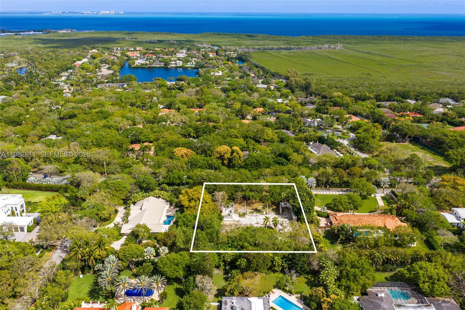 An aerial view shows a rectangular lot containing ruins surrounded by lush green trees — 10550 Old Cutler Rd, Coral Gables FL 33156, CORAL GABLES, FL