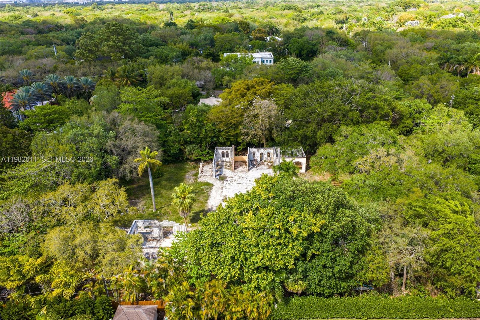 An aerial view shows a heavily wooded lot containing the ruins of a residential structure — 10550 Old Cutler Rd, Coral Gables FL 33156, CORAL GABLES, FL