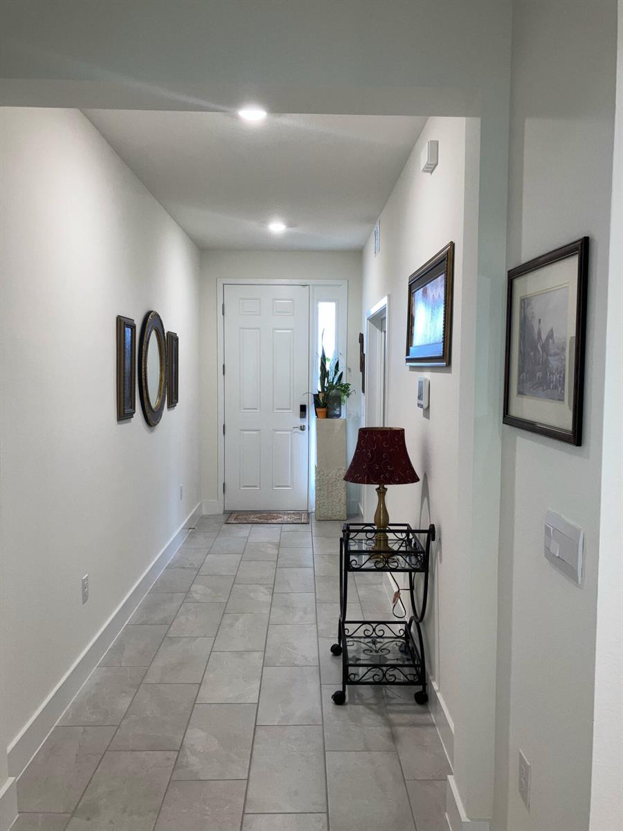 A hallway with light tile flooring leads to a dining area and living room — 4258 SW 53rd Lane Road, Ocala FL 34474, OCALA, FL