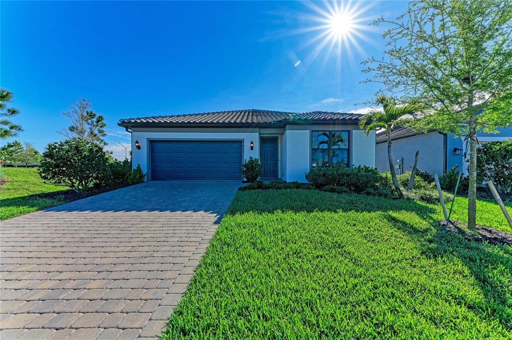 A single-story house with a paved driveway, a two-car garage, and a tiled roof — 5637 SILVERSIDE PINE COURT, BRADENTON, FL
