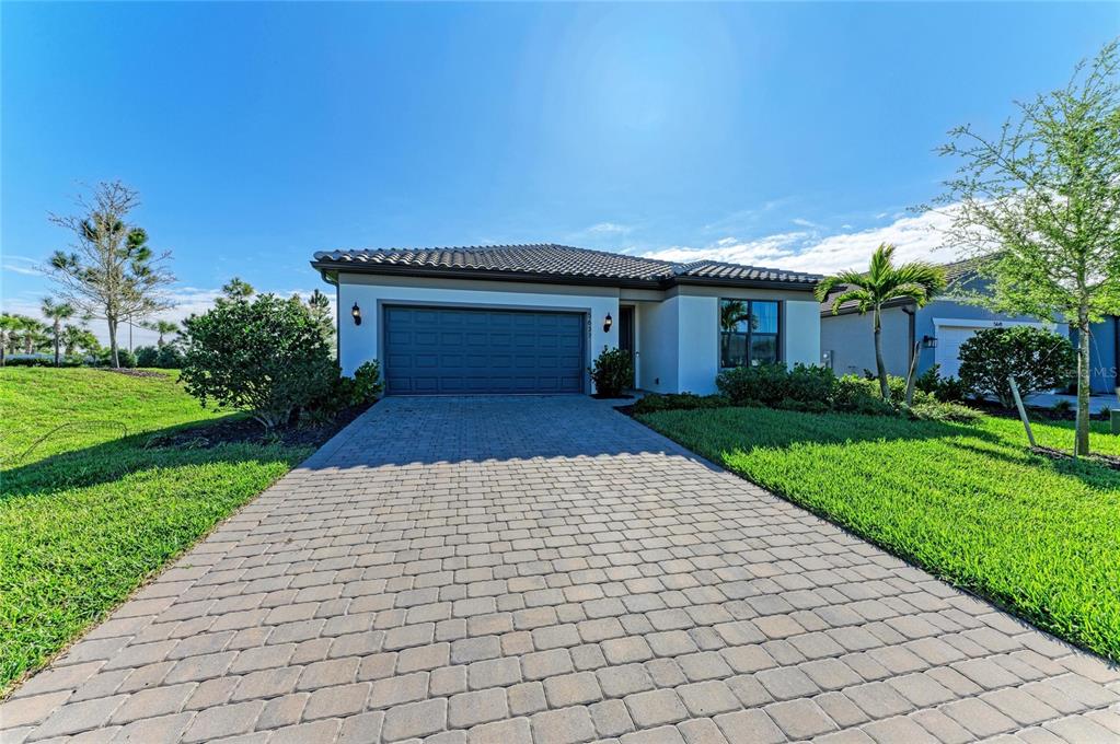 A single-story house with a paved driveway, a two-car garage, and a tiled roof — 5637 SILVERSIDE PINE COURT, BRADENTON, FL