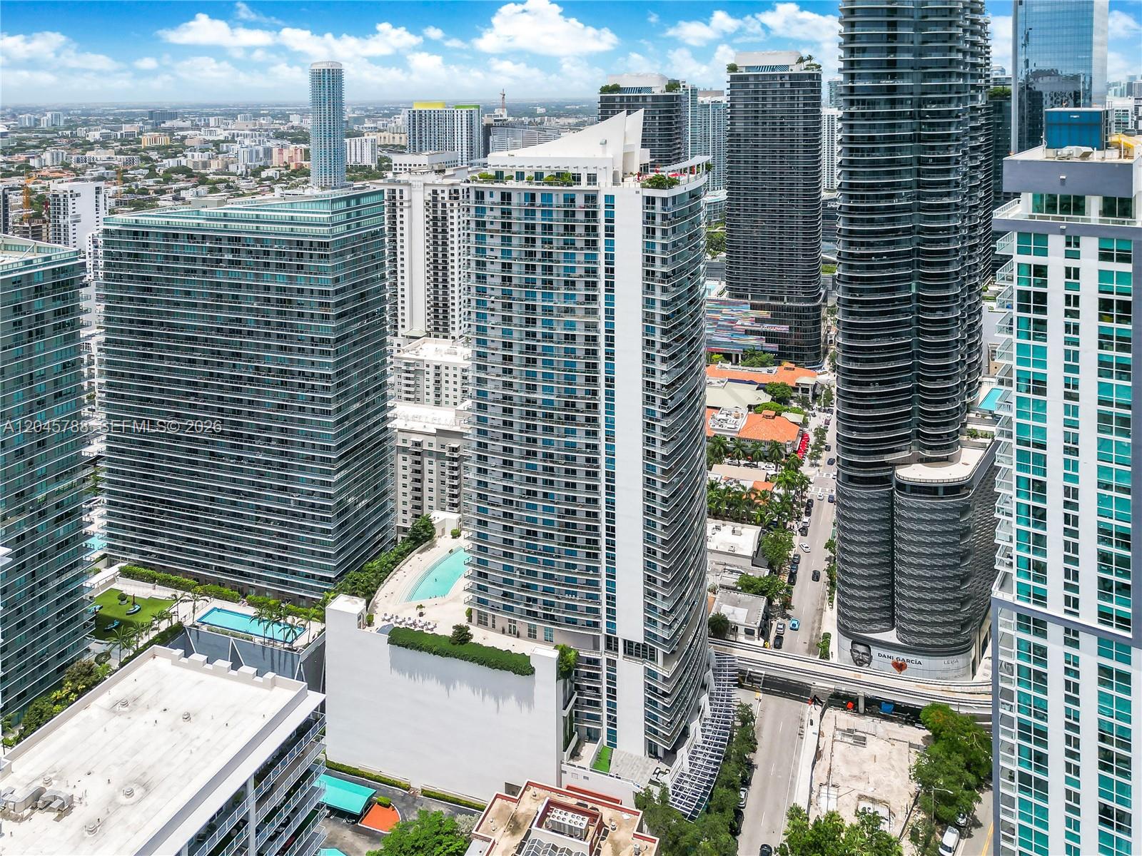 An aerial view of a tall residential skyscraper surrounded by other high-rise buildings in Miami — 1100 S Miami Ave # 1607, Miami FL 33130, MIAMI, FL