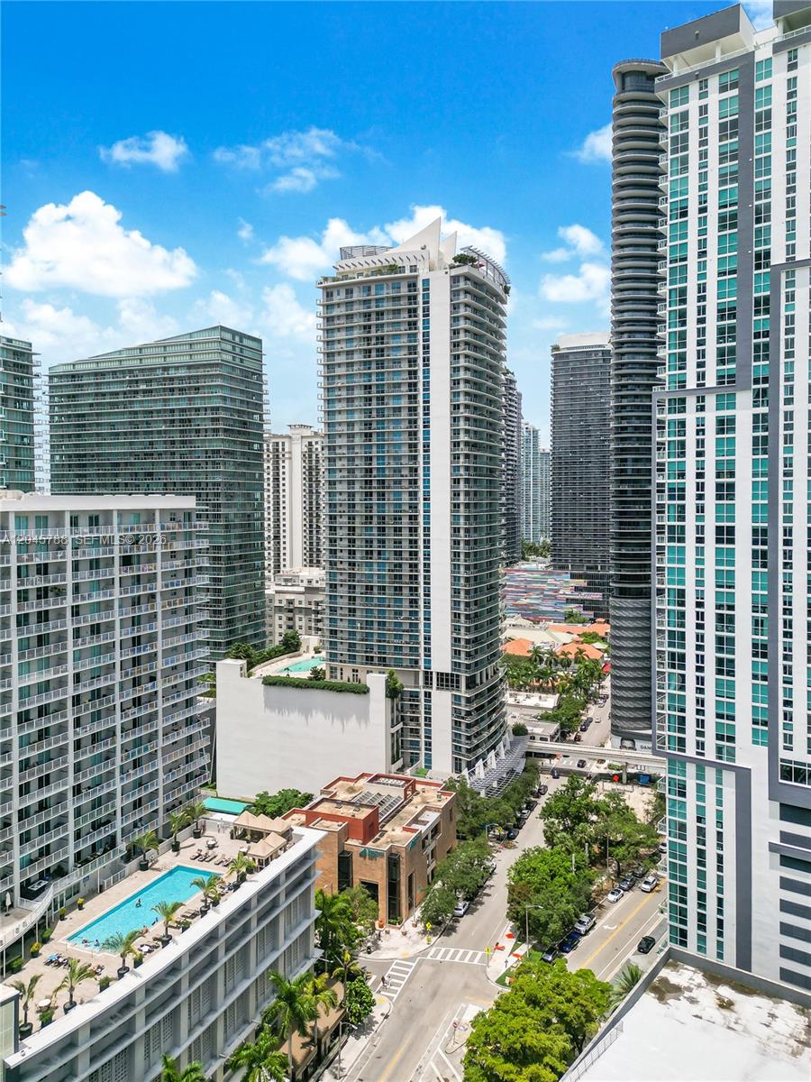 An elevated view shows several modern high-rise apartment buildings and a street with trees — 1100 S Miami Ave # 1607, Miami FL 33130, MIAMI, FL