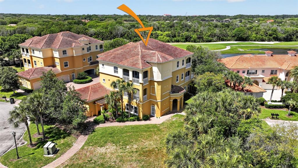 An aerial view shows a three-story yellow stucco building with a tiled roof — 40 CASA BELLA CIRCLE UNIT 1102, PALM COAST, FL