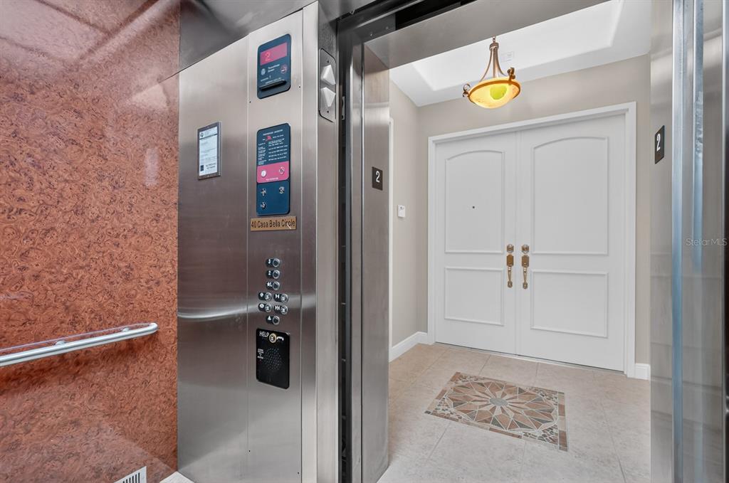 An elevator opens into a private foyer with double doors and a decorative tile inlay — 40 CASA BELLA CIRCLE UNIT 1102, PALM COAST, FL