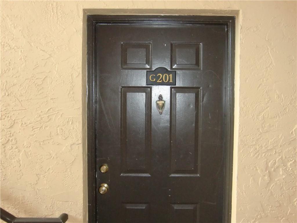 A dark brown apartment door labeled G201 is set into a textured beige wall — 4045 Mcnab Road # G, Pompano Beach FL 33069, POMPANO BEACH, FL