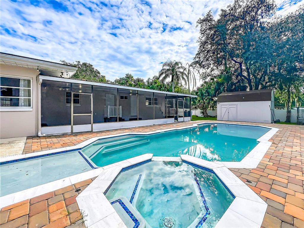 A backyard features a swimming pool, a hot tub, a screened-in patio, and a shed — 52 CLARK STREET, OVIEDO, FL