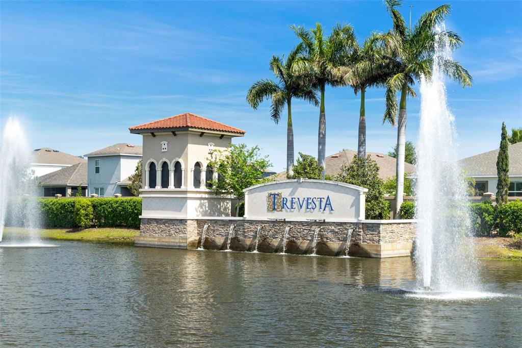 A stone monument sign for Trevesta sits in front of a pond with fountains — 5526 GAVELLA COVE, PALMETTO, FL