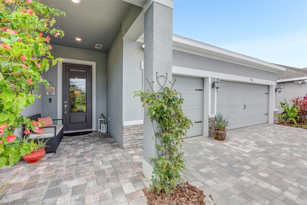 The exterior of a house features a paved driveway, a covered entryway, and a garage — 5526 GAVELLA COVE, PALMETTO, FL