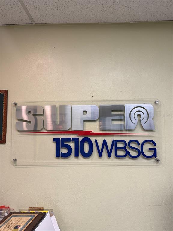 A wall-mounted sign displays the text SUPER 1510 WBSG on a clear acrylic panel — PR-306 K0 H7 PALMAREJO WARD, LAJAS, PR