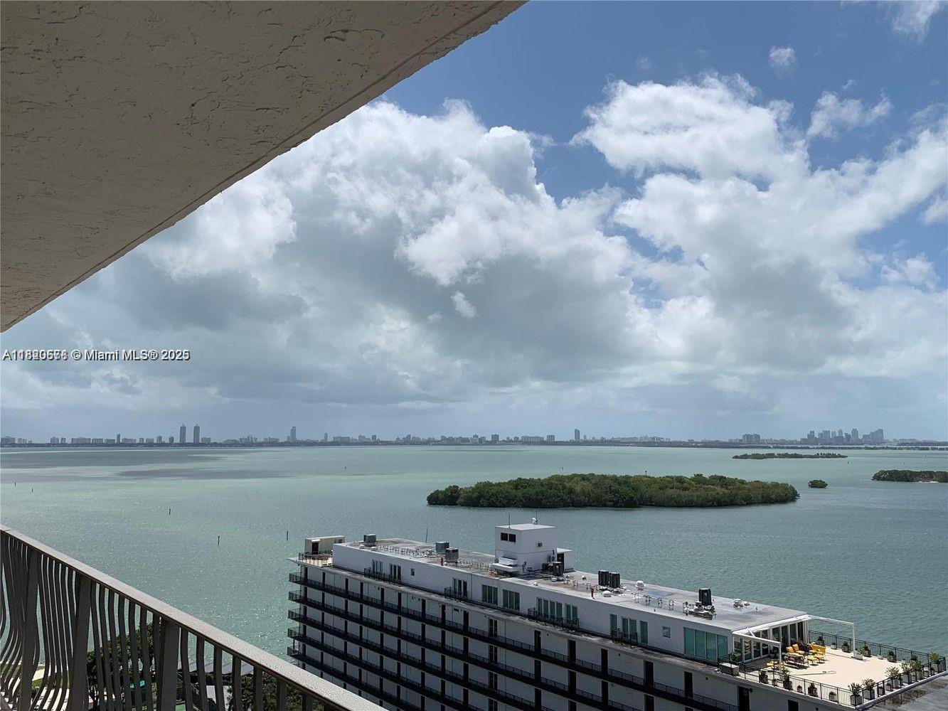 A high-angle view from a balcony overlooks a bay with islands and a large building — 780 NE 69th St # 1507, Miami FL 33138, MIAMI, FL