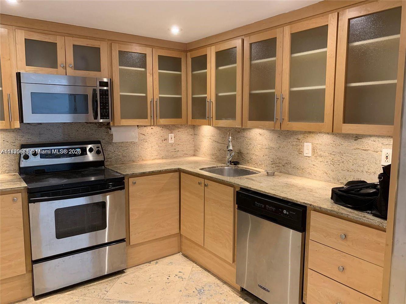 A kitchen featuring light wood cabinets, stainless steel appliances, and granite countertops — 780 NE 69th St # 1507, Miami FL 33138, MIAMI, FL