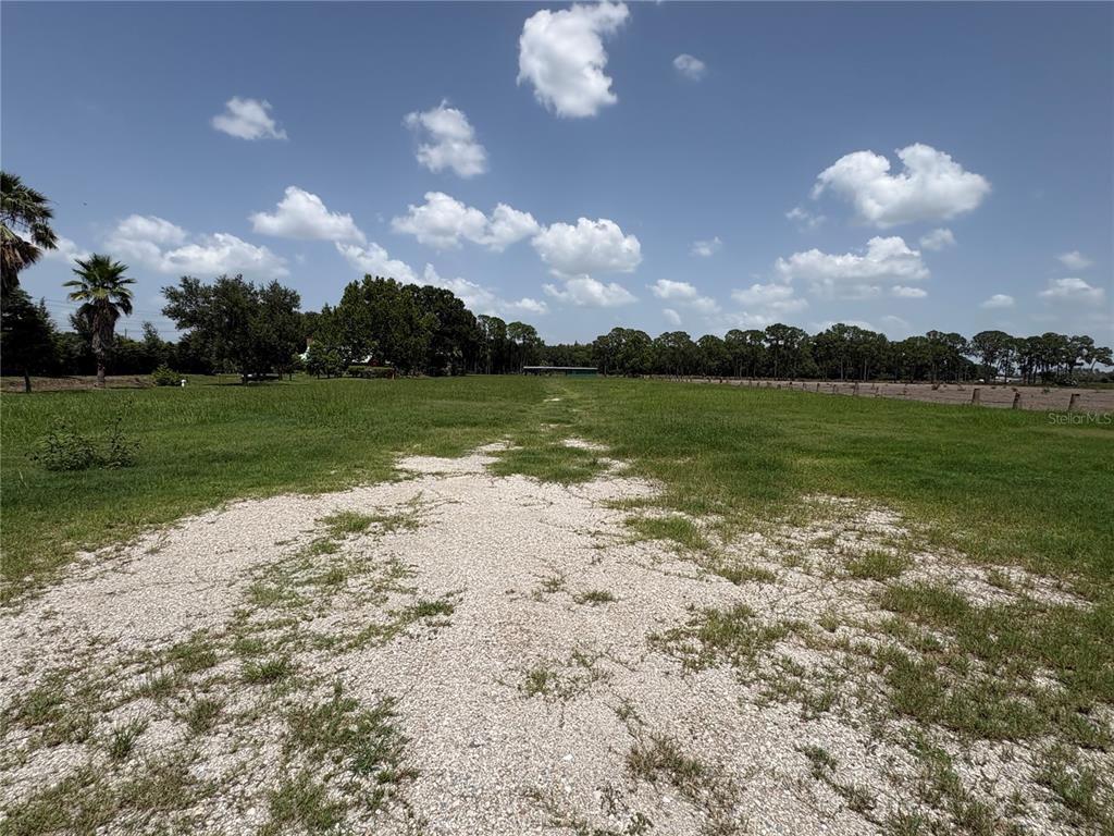 A gravel path leads through a large, grassy field toward a line of trees — 0 HAMILTON ROAD, LAKELAND, FL