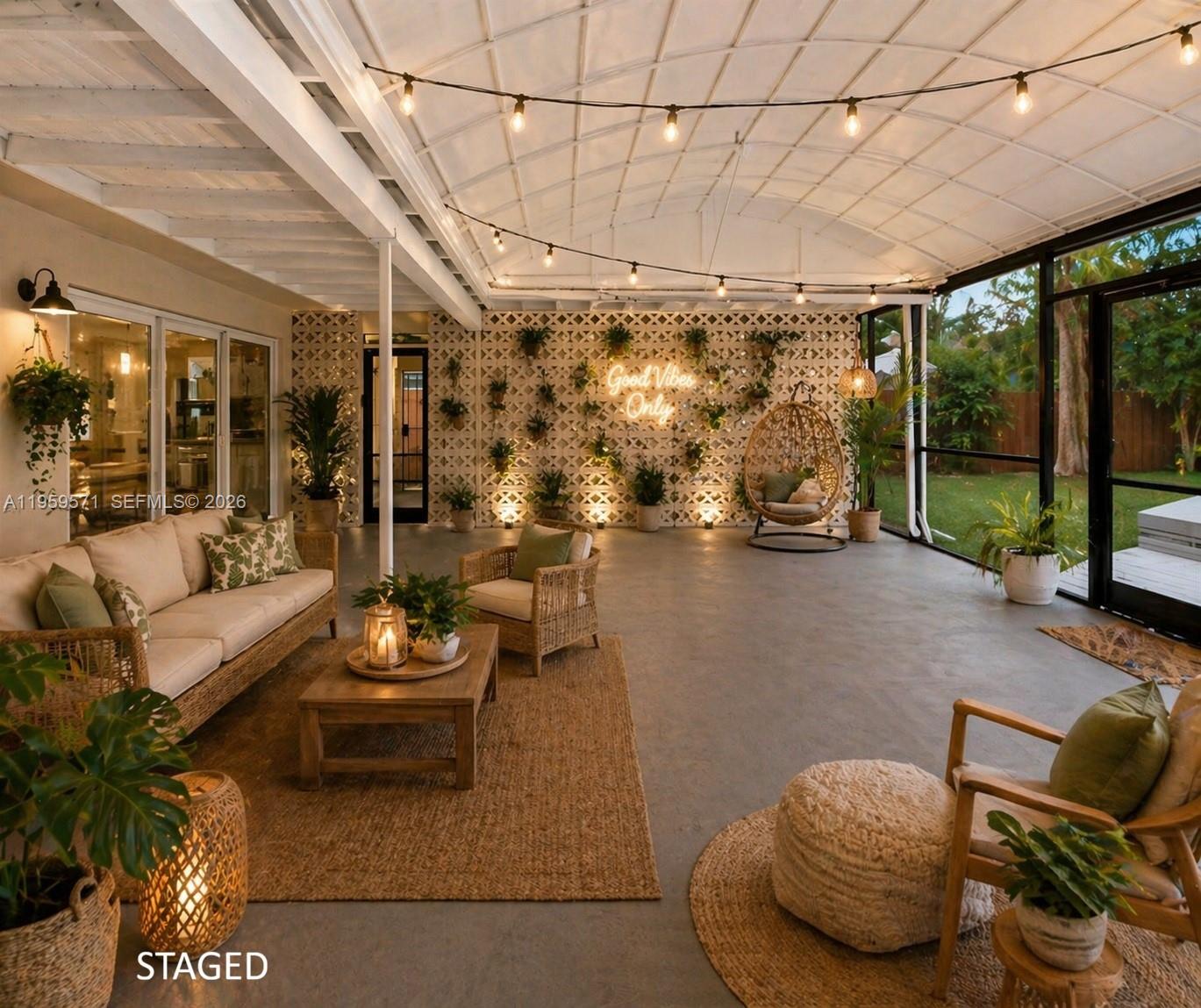 A furnished covered patio features a lattice wall, string lights, and a view of the yard — 1507 Harding St, Hollywood FL 33020, HOLLYWOOD, FL