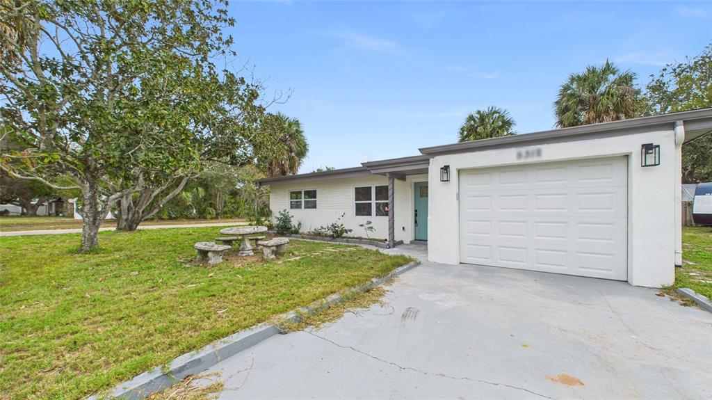 A single-story house with a white brick facade, a one-car garage, and a front yard — 5312 BERKLEY ROAD, NEW PORT RICHEY, FL