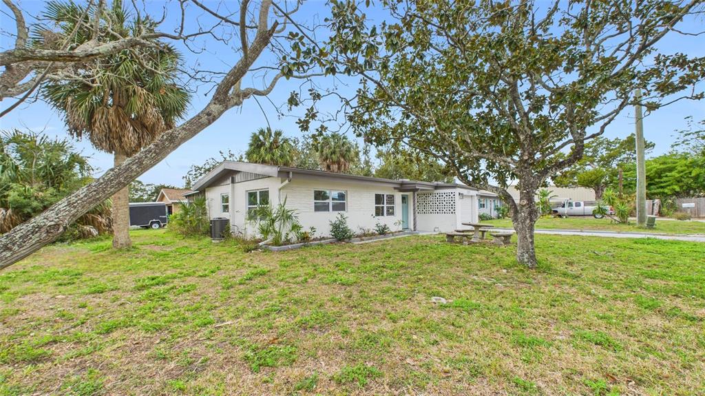 A single-story white brick house with a flat roof sits on a grassy lot — 5312 BERKLEY ROAD, NEW PORT RICHEY, FL