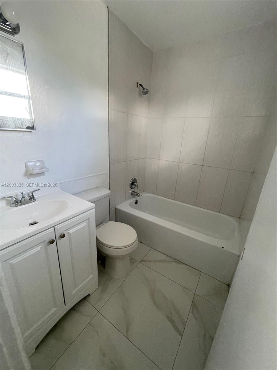 This bathroom features a white vanity, a toilet, and a tiled shower-tub combination — 1101 S K St # 16, Lake Worth FL 33460, LAKE WORTH, FL